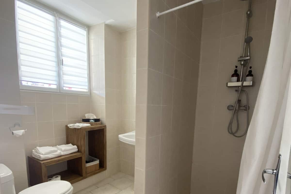 Ein Badezimmer mit Dusche, Toilette und Waschbecken.