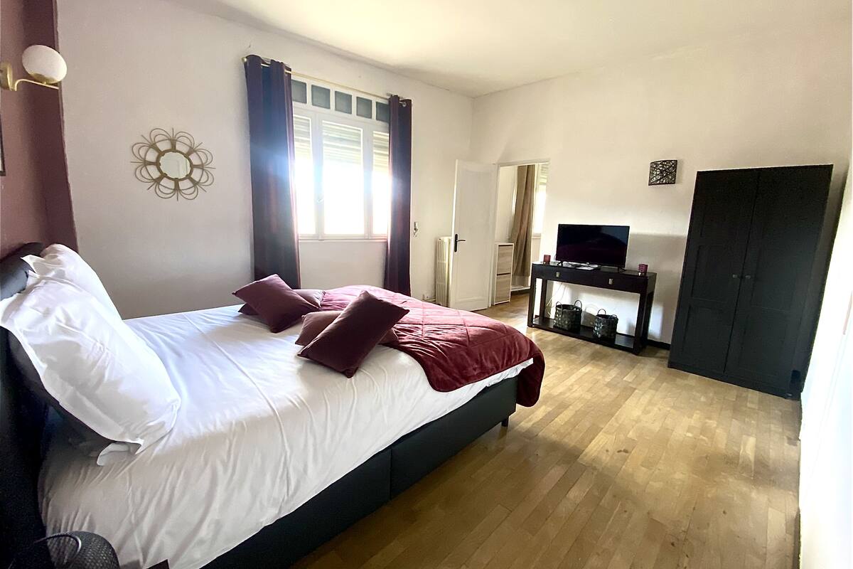 Ein Schlafzimmer mit einem Bett, einem Fernseher, einem Schreibtisch und einem Kleiderschrank.