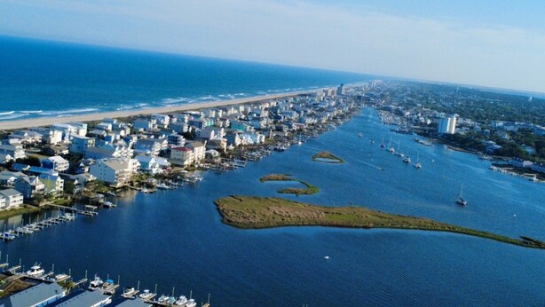 An aerial view of a coastal town with a marina, buildings, and a beach. - 2 BR/2.5 BA beautiful, spacious waterfront Carolina Beach condo (Carolina Beach)