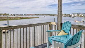 A wooden deck with two turquoise Adirondack chairs, a view of a calm river with boats, and a marina in the background. - 2 BR/2.5 BA beautiful, spacious waterfront Carolina Beach condo (Carolina Beach)