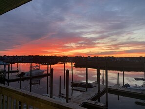 Ein Yachthafen mit vertäuten Booten und einem Sonnenuntergang über ruhigem Wasser.