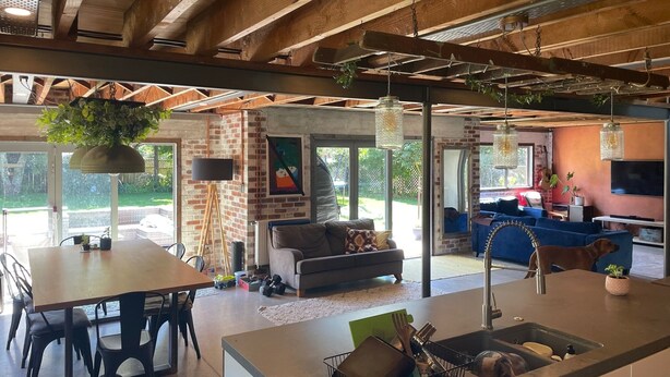 Un'ampia zona giorno con angolo cottura, tavolo da pranzo e posti a sedere.