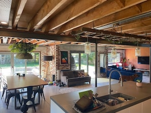 A spacious living area with a kitchen, dining table, and seating.