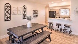 Een moderne keuken met een centraal kookeiland, barstoelen en decoratieve muurkunst.