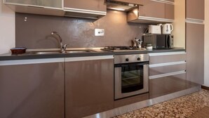Une cuisine moderne équipée d’appareils électroménagers en acier inoxydable, d’un four encastré et d’un four à micro-ondes.