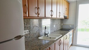 Una cocina con encimeras de granito, electrodomésticos de acero inoxidable y armarios de madera.