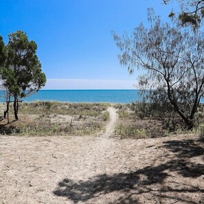 A beach path leading to the sea with sparse vegetation and a clear sky. - Lemac - Direct Access to Toogoom Beach-Sleeps 8-2 Smart TV's-Wifi-Pets (Toogoom)