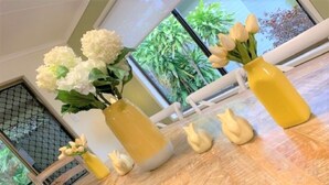 Ett bord med vaser fulla av blommor och dekorativa föremål.