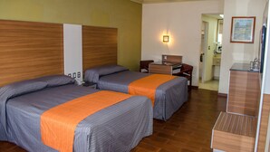 A hotel room with two beds, a desk, a chair, a nightstand, and a ceiling fan. - Hotel Premier (Hermosillo)