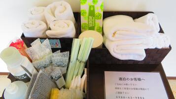 A gift basket with toiletries including towels, a soap bar, and a bottle of lotion.