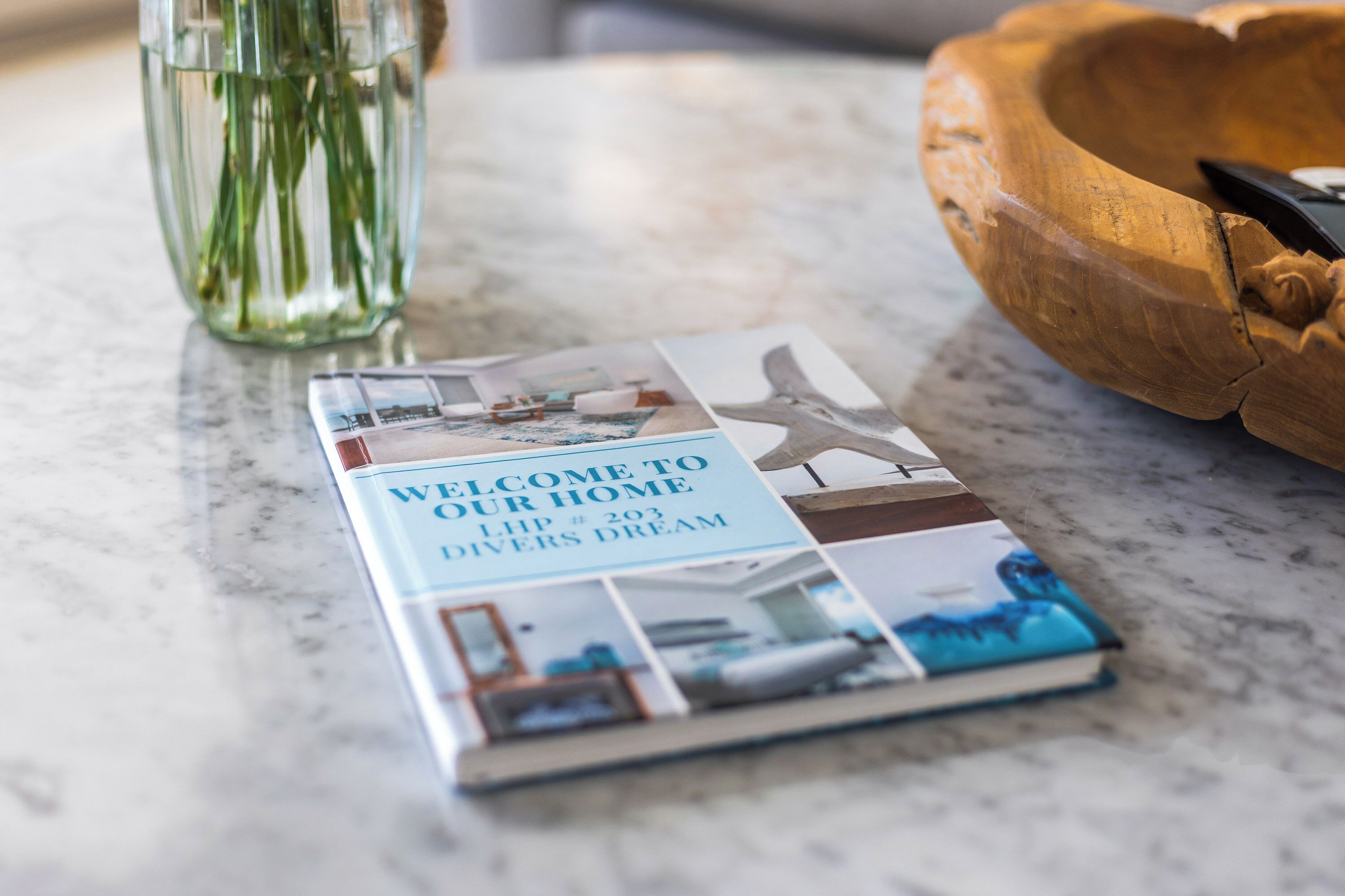 Une brochure intitulée « BIENVENUE CHEZ NOUS » est posée sur une surface en marbre.