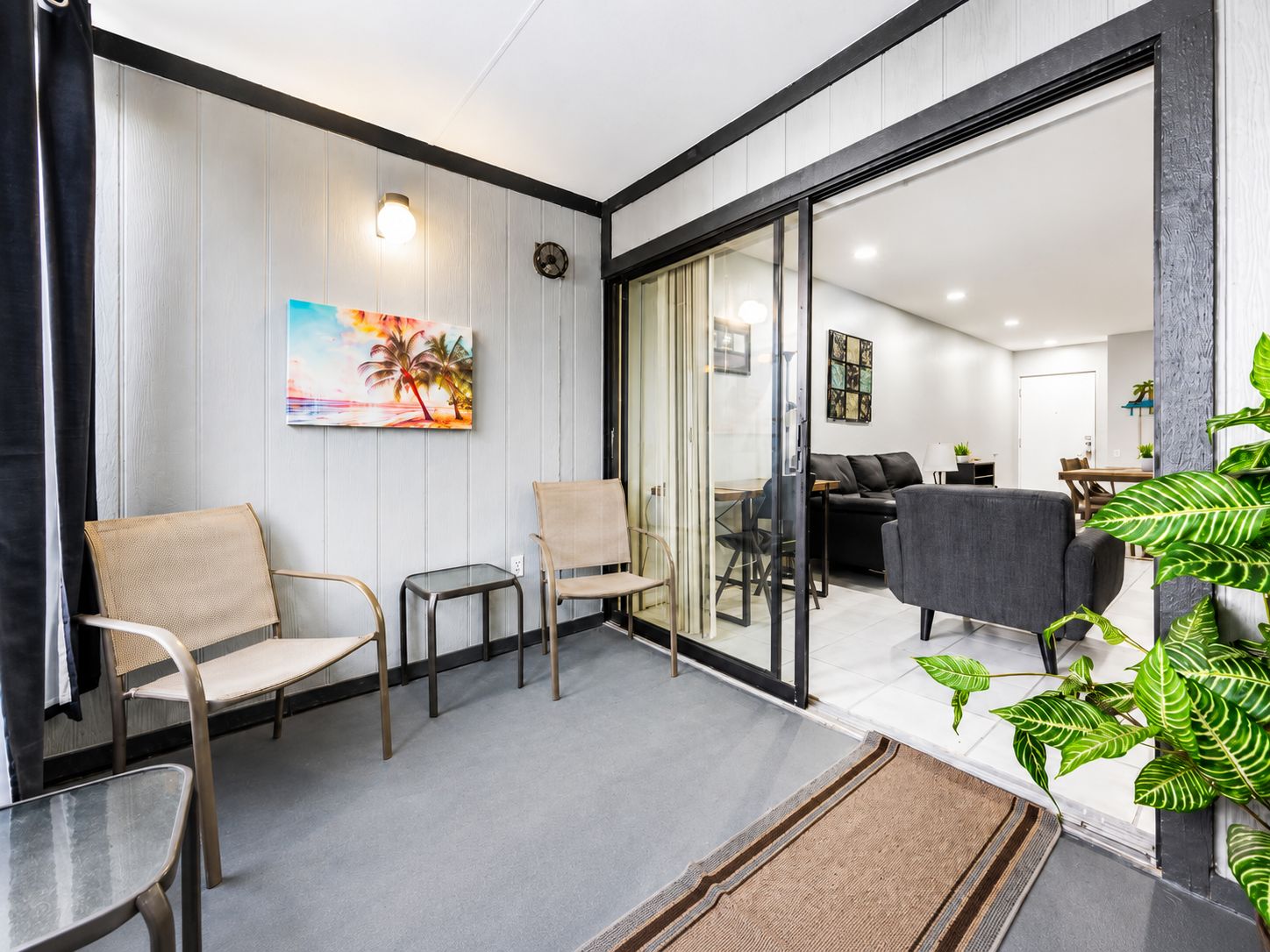 A modern interior with a seating area, a dining space, and a living room.