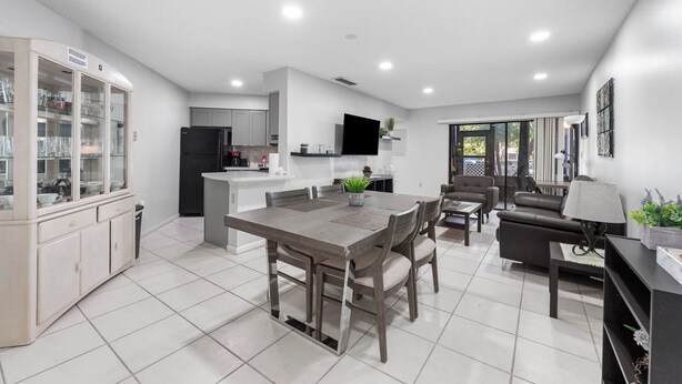 Una cocina moderna con comedor, sala de estar y televisor montado en la pared.