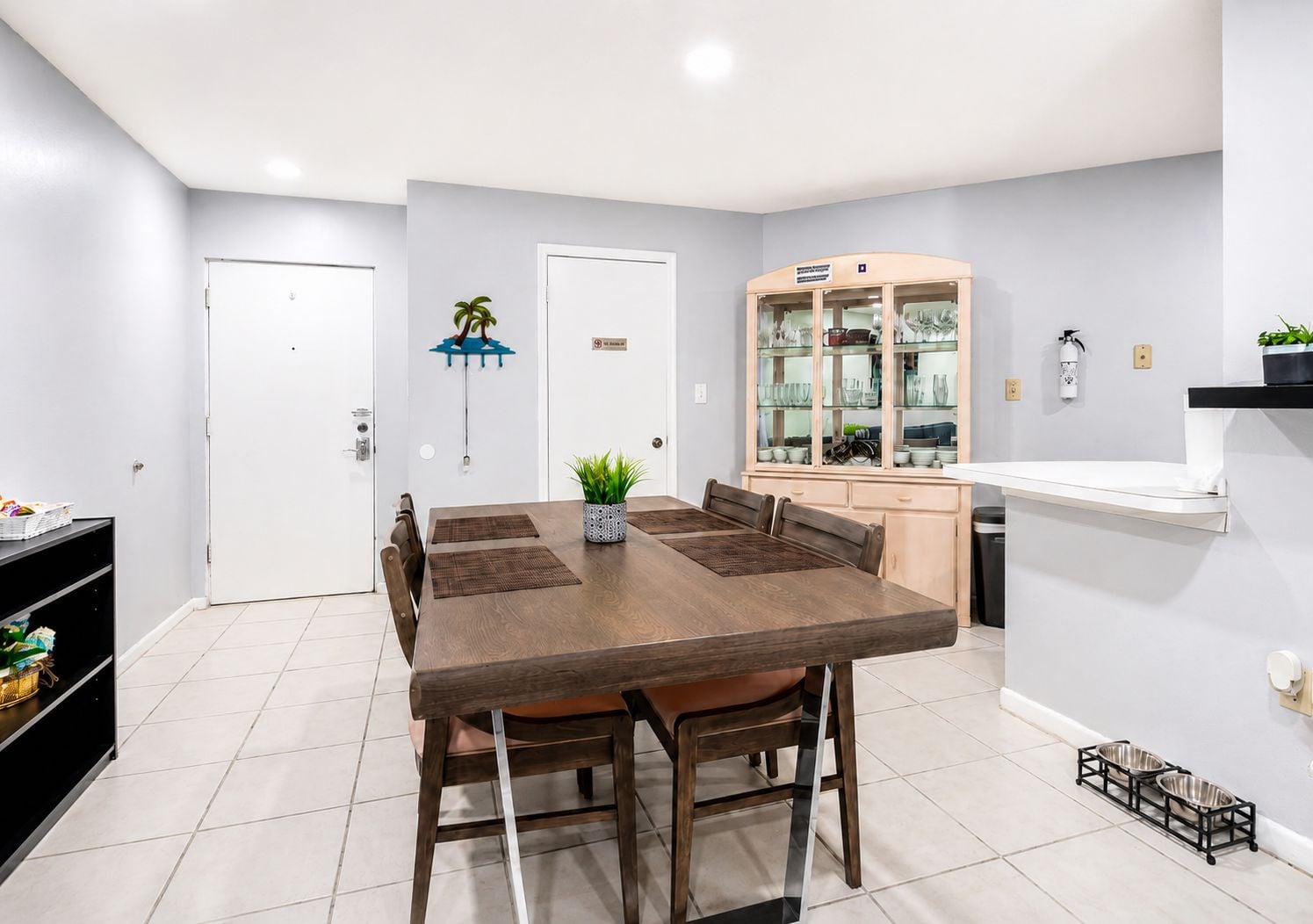 A dining area with a wooden table, chairs, and a small plant.