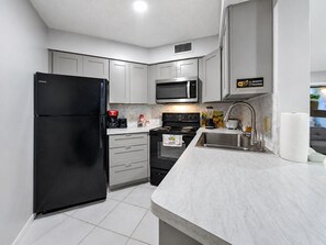 A modern kitchen with a refrigerator, microwave, stove, and sink. - 3697 Orlando Vacational Apartment 1st floor near Universal Studios (Orlando)