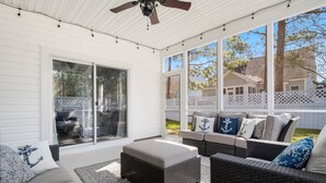 A covered patio area with wicker furniture, a ceiling fan, and large windows offering views of the backyard. - Pet Friendly Long-Term Rental - 25 Day Min  - Fenced Backyard - Grill (St. James)
