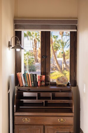 A wooden bookcase with books and a small decorative item. - ONE block from the beach at main st. (Loreto)