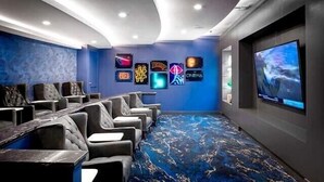 A cinema room with a curved ceiling, a large screen, and a row of comfortable seating. - New! Master Suite w/ Skyline Views - Art Dist (Houston)