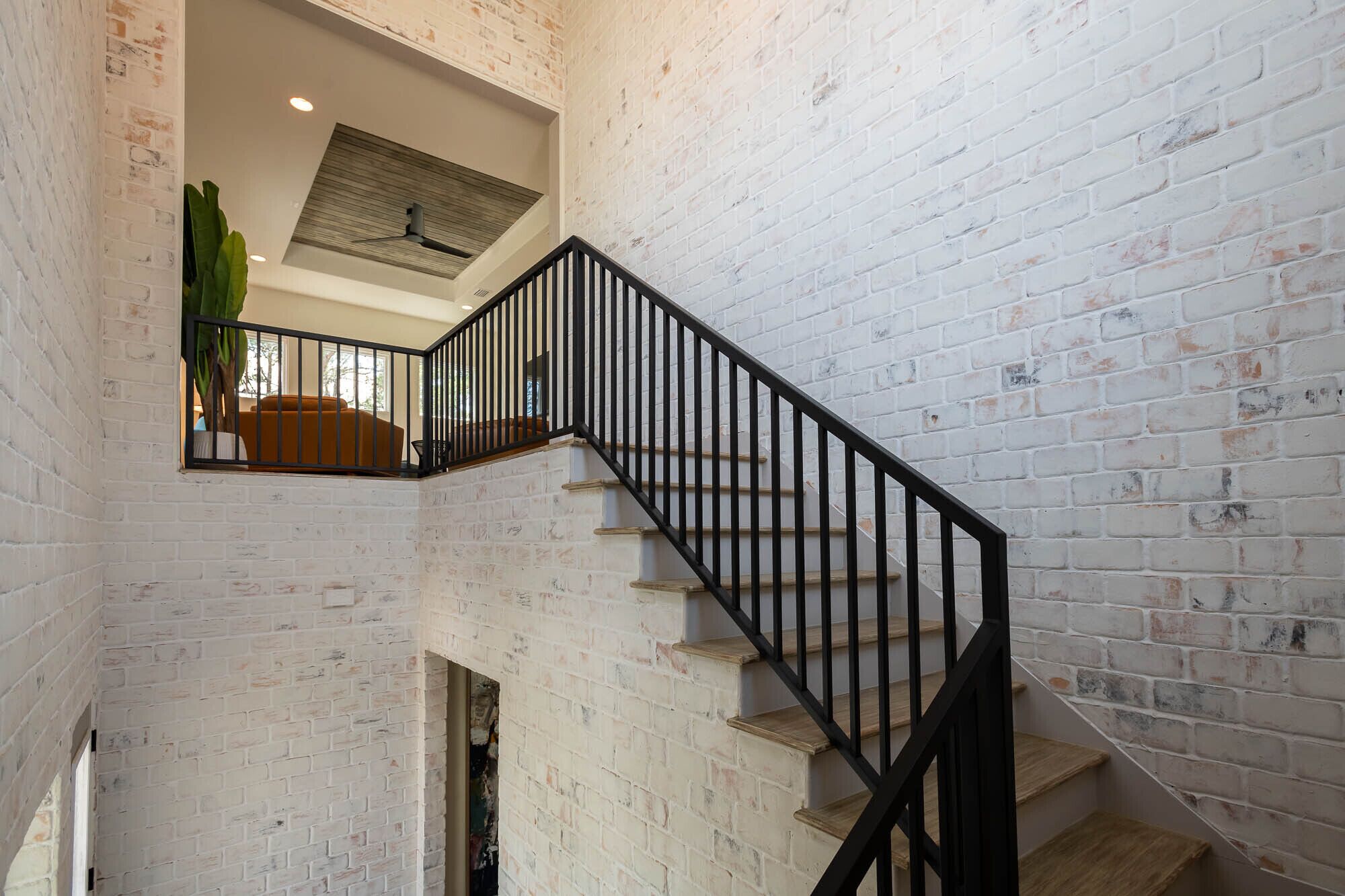 Un escalier avec des rampes noires menant à un niveau supérieur.