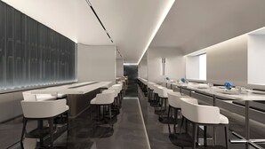 A modern conference room with white tables and chairs, a long table with blue flowers, and a large window on the right. - Citadines Gaoxin Chengdu (Chengdu)
