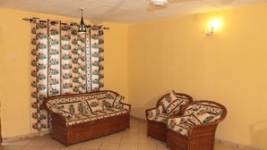 A living room with a wicker sofa and two armchairs, a ceiling fan, and patterned curtains. - Stay.Plus Kikambala Holiday Home (Mtwapa)