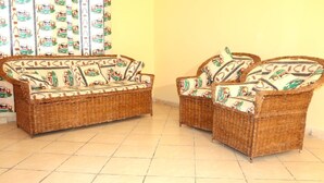 A wicker sofa set with patterned cushions in a room with tiled flooring. - Stay.Plus Kikambala Holiday Home (Mtwapa)