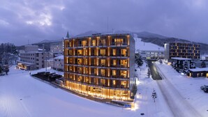 A modern hotel with multiple floors and a snow-covered landscape. - Fenix West (Furano)