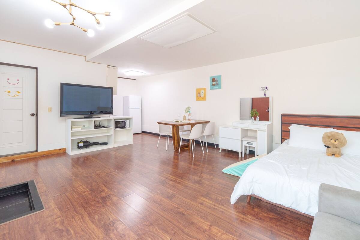 Une chambre d’hôtel avec un lit, un bureau, une télévision et une chaise.