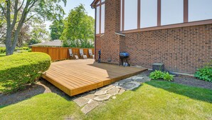 A backyard with a wooden deck, stone pathway, and a barbecue grill. - Bike & Kayak: Lakefront Prospect Heights Home (Prospect Heights)