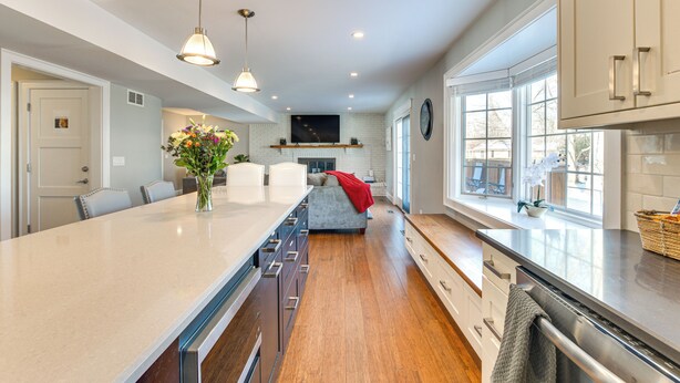 A modern kitchen with a long island, pendant lights, a built-in oven, and a large window providing natural light. - Bike & Kayak: Lakefront Prospect Heights Home (Prospect Heights)