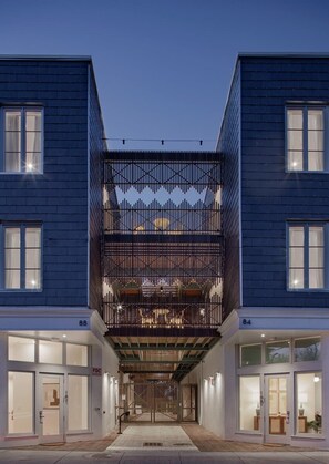 A modern building with a central atrium, large windows, and a gated entrance. - The Iris, Superior Suite (Charleston)