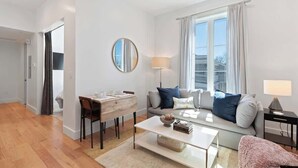Un salon moderne comprenant un canapé, une table basse et un coin repas avec des chaises et une table.