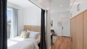 Une chambre d’hôtel moderne équipée d’un lit, d’un bureau et d’une armoire.