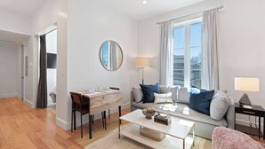 Un salon moderne comprenant un canapé, une table basse et un coin repas avec une table et des chaises en bois.