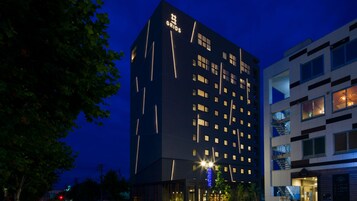 A multi-story hotel with a modern design, featuring a prominent 'GRIDS' sign on the facade.