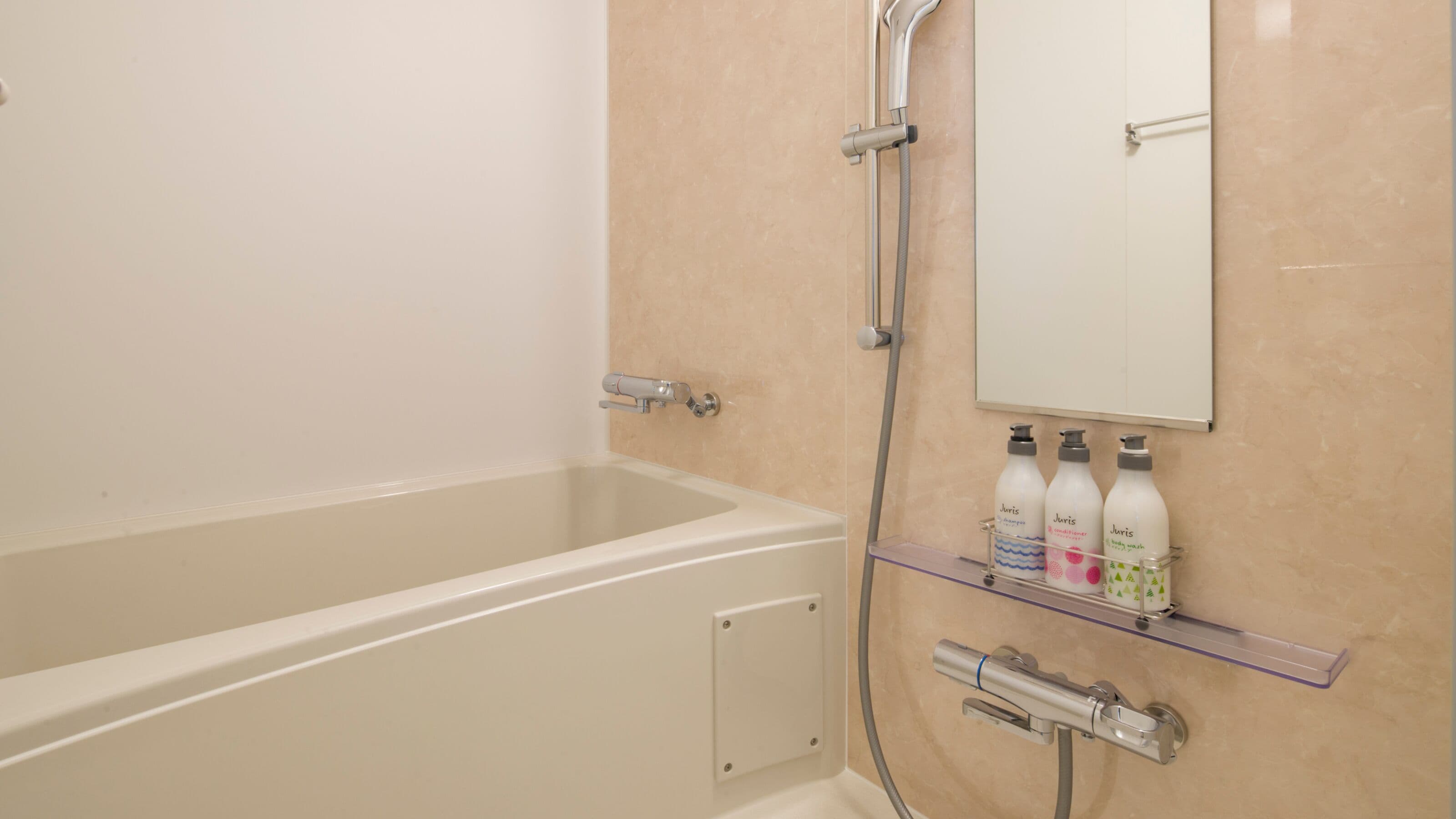 A bathroom with a bathtub, a shower, and a shelf with toiletries.