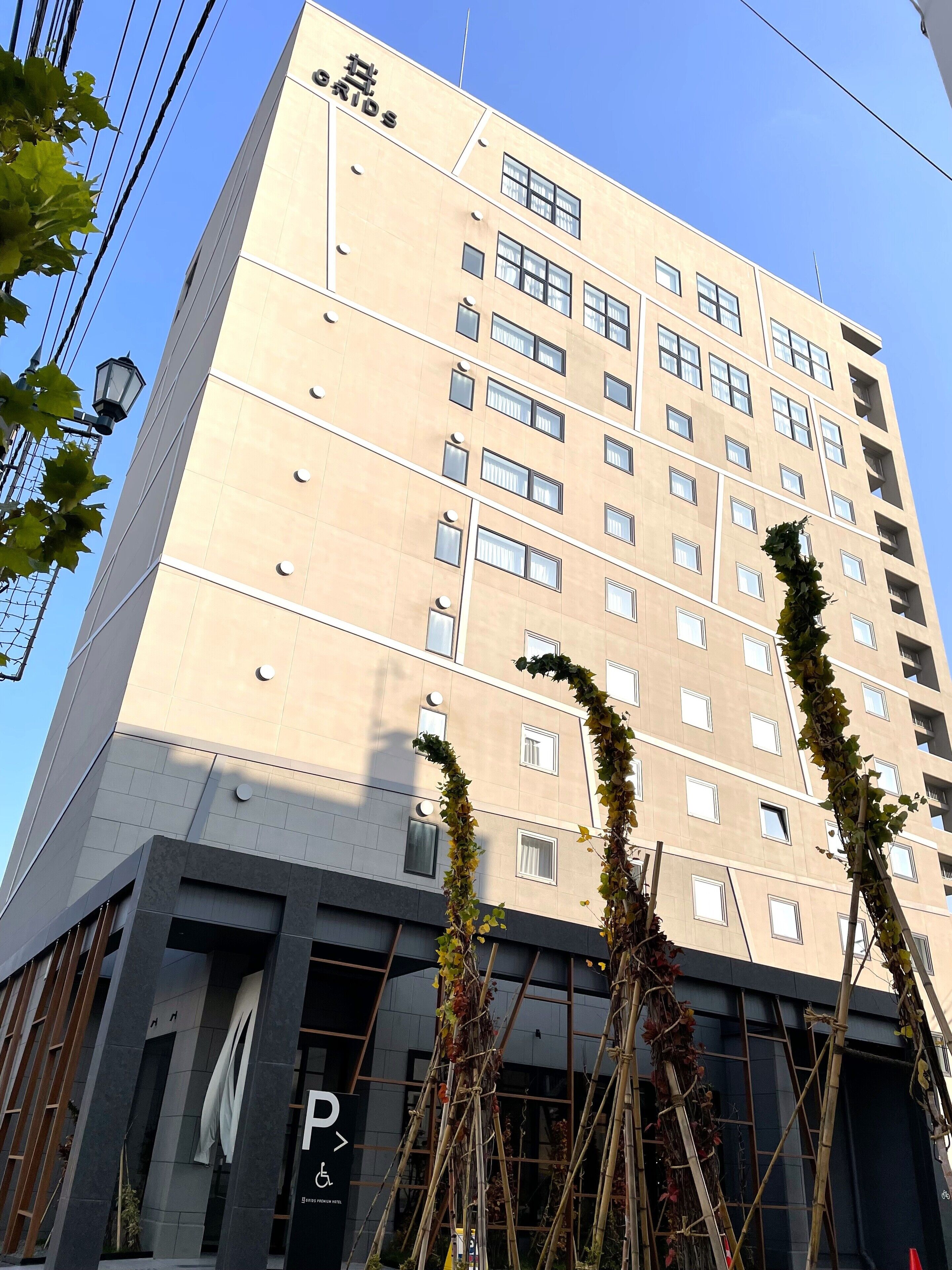 A multi-story hotel with a beige facade, numerous windows, and a sign indicating a parking area.