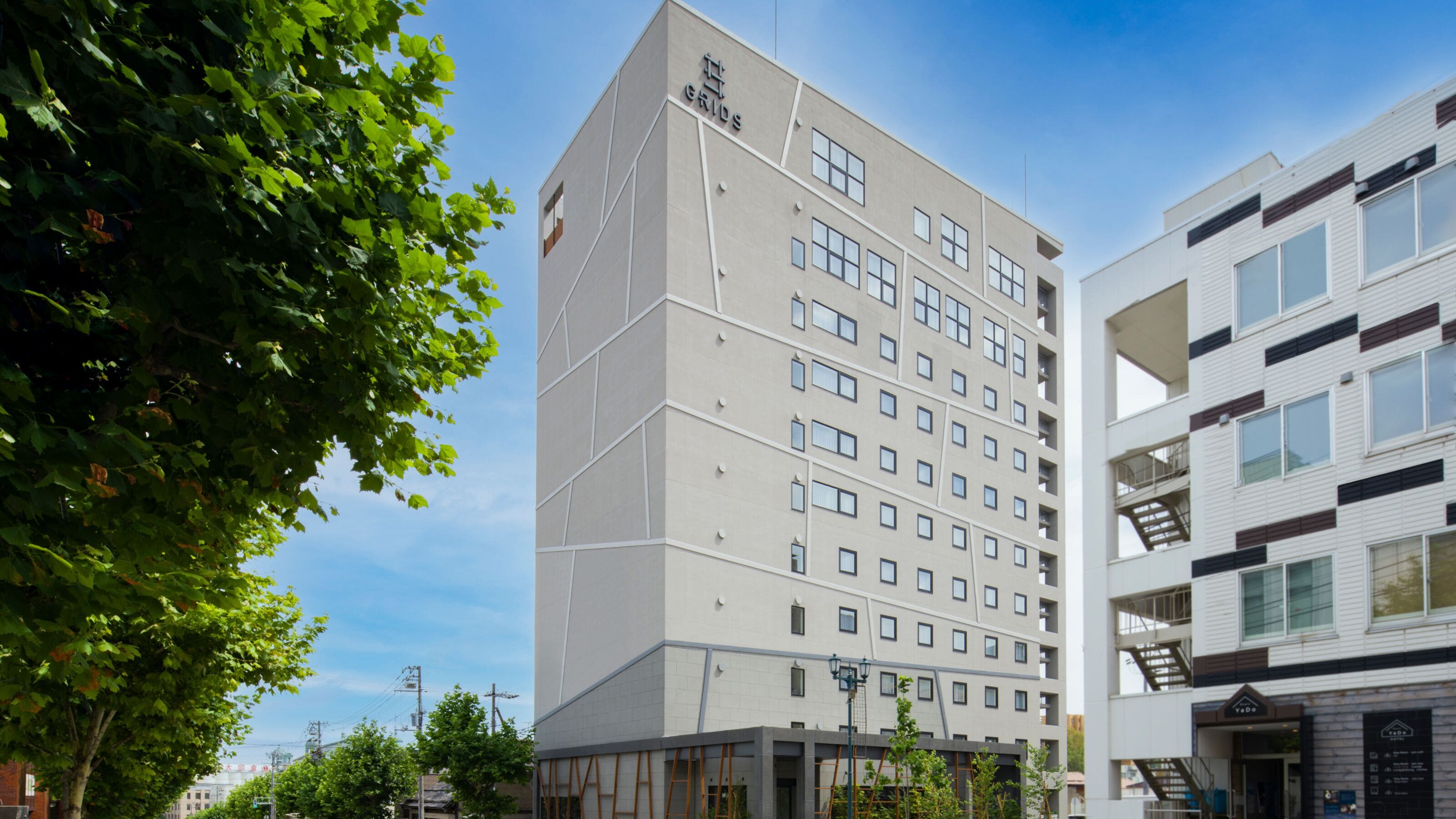 Un moderno edificio de hotel con varios pisos, un cartel llamativo y una vista despejada del entorno urbano.