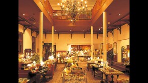 A spacious lobby with high ceilings, ornate chandeliers, and multiple seating areas.