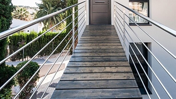 Una escalera con barandillas metálicas que conduce a una puerta.
