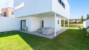 A modern house with a covered patio, a large vase, and a sofa. - Villa Puerto Blanco close to the Beach with Pool & Wi-Fi (Vinaròs)