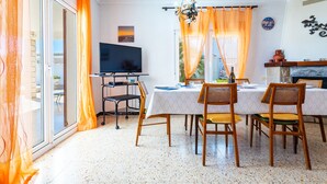 Un comedor con una mesa para cuatro, un televisor y una chimenea.