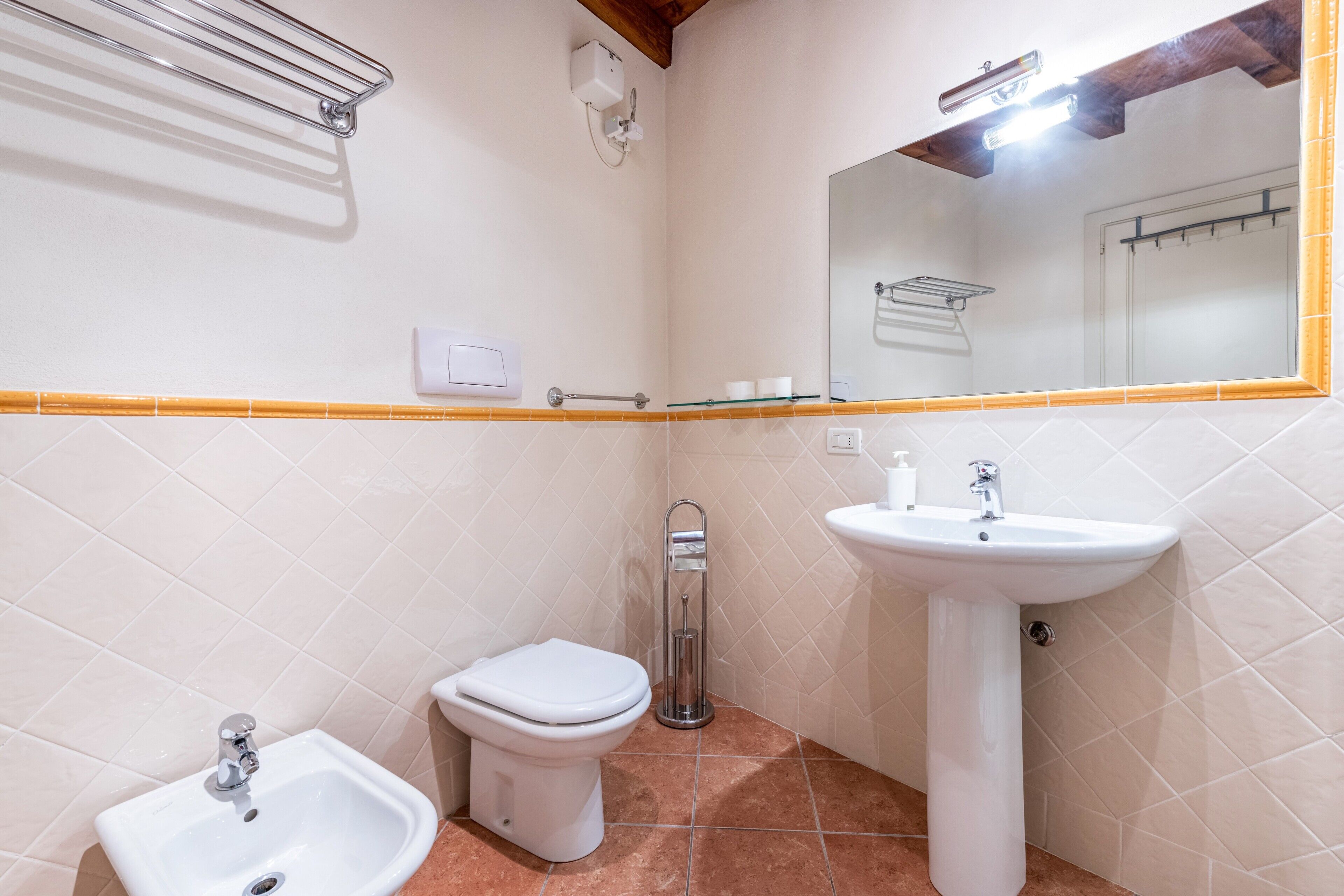 Une salle de bain avec des toilettes, un lavabo et un miroir.