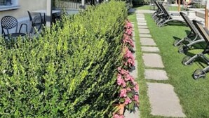 A garden with a pathway, outdoor seating, and a pergola structure. - Apartment 'Antica Torre Byron' with Shared Pool, Wi-Fi and Air Conditioning (San Felice del Benaco (BS))