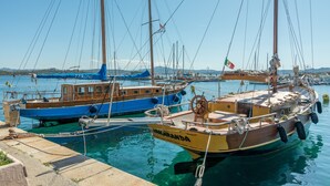 A marina with several boats docked, including a yellow boat named 'MOKURANDA' and a blue boat with a cabin. - Apartment 'Rifla Vacanze' with Terrace & Wi-Fi (La Maddalena)