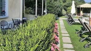 A garden with a pathway, outdoor seating, and a pergola.