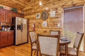 Enjoy a warm and inviting kitchen with a refrigerator, coffee maker, and dining area.