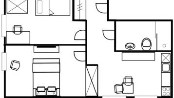 Plano de planta de una habitación de hotel que incluye cama, escritorio, silla, mesita y baño.