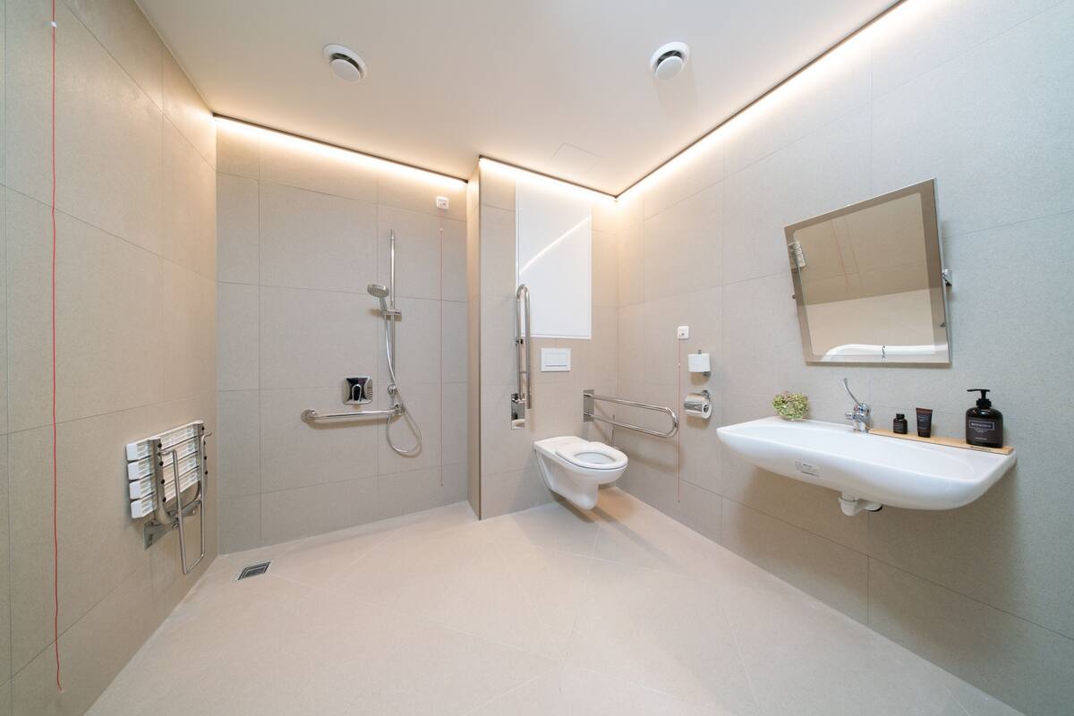 A modern bathroom with a shower, toilet, and sink.