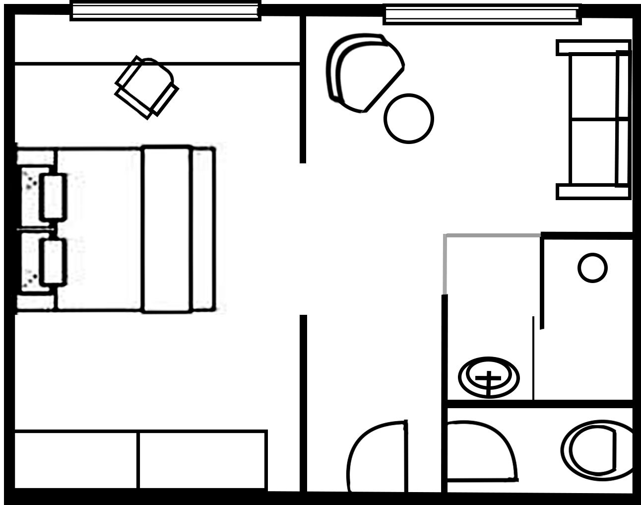 A floor plan with a bed, a desk, a chair, a small table, and a toilet.